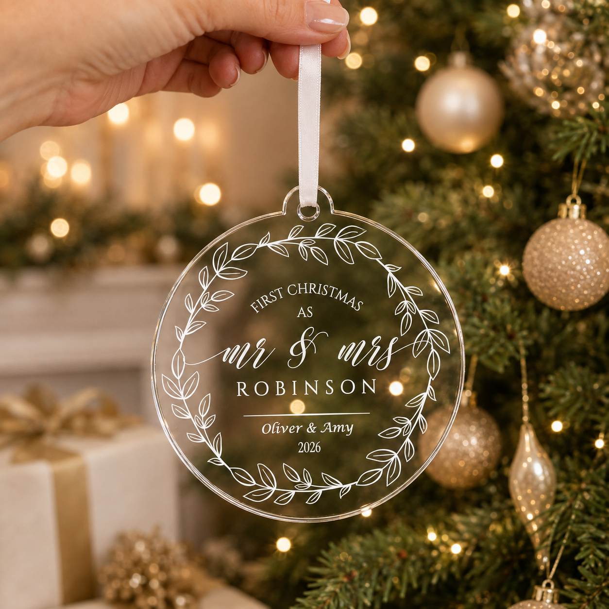 Hand holding the personalised Mr and Mrs wreath bauble by its white ribbon