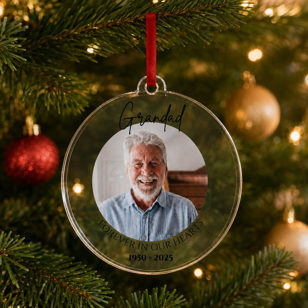 Memorial Christmas bauble hanging on a Christmas tree with warm lights