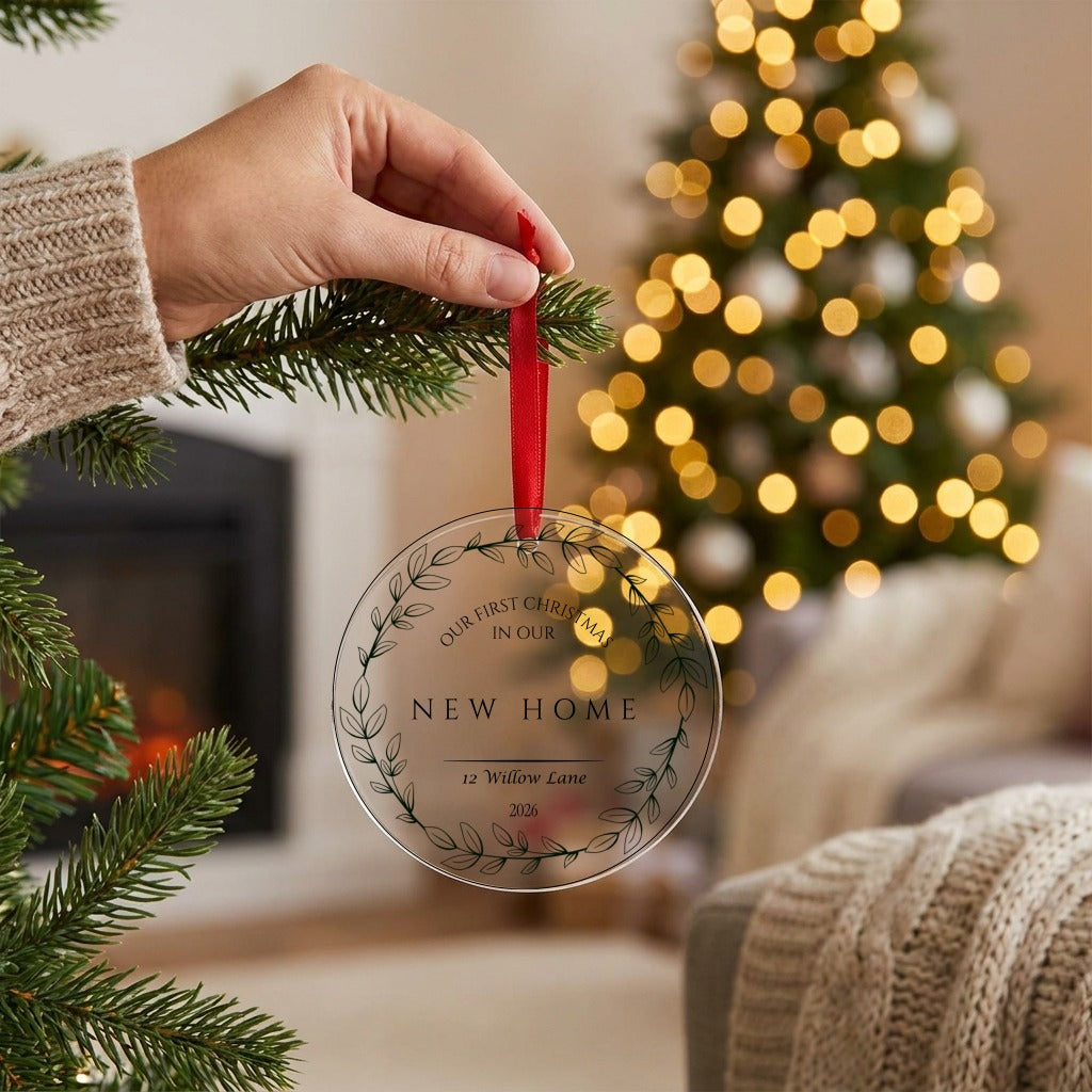 Hand hanging the personalised new home bauble on the Christmas tree