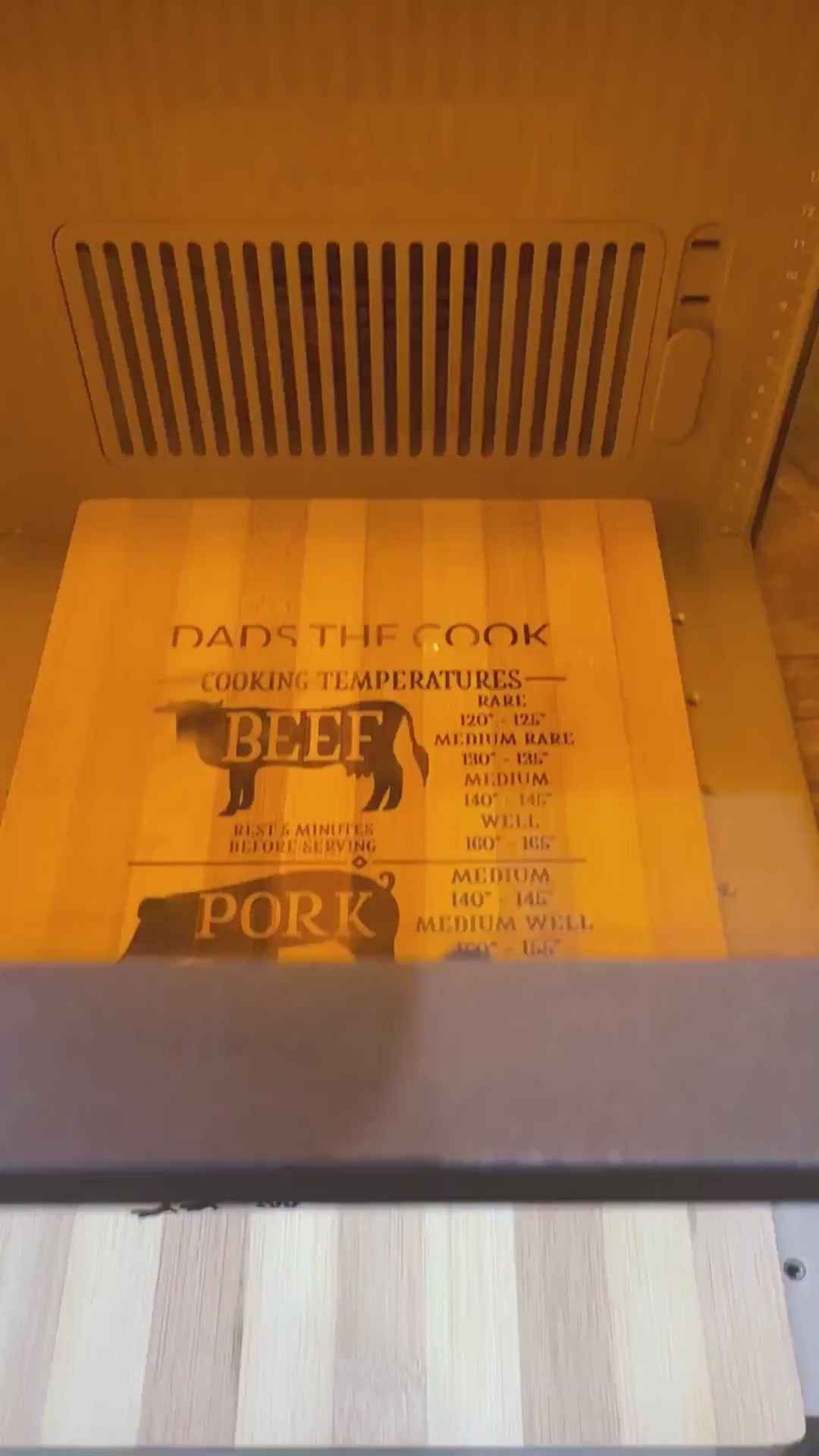 Bamboo cooking temperature board being laser engraved