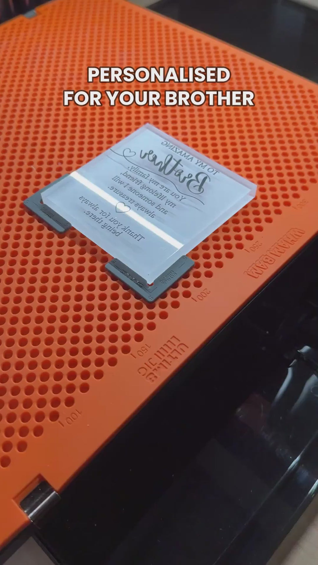 Personalised brother gift clear acrylic keepsake block being unwrapped in the AETN workshop
