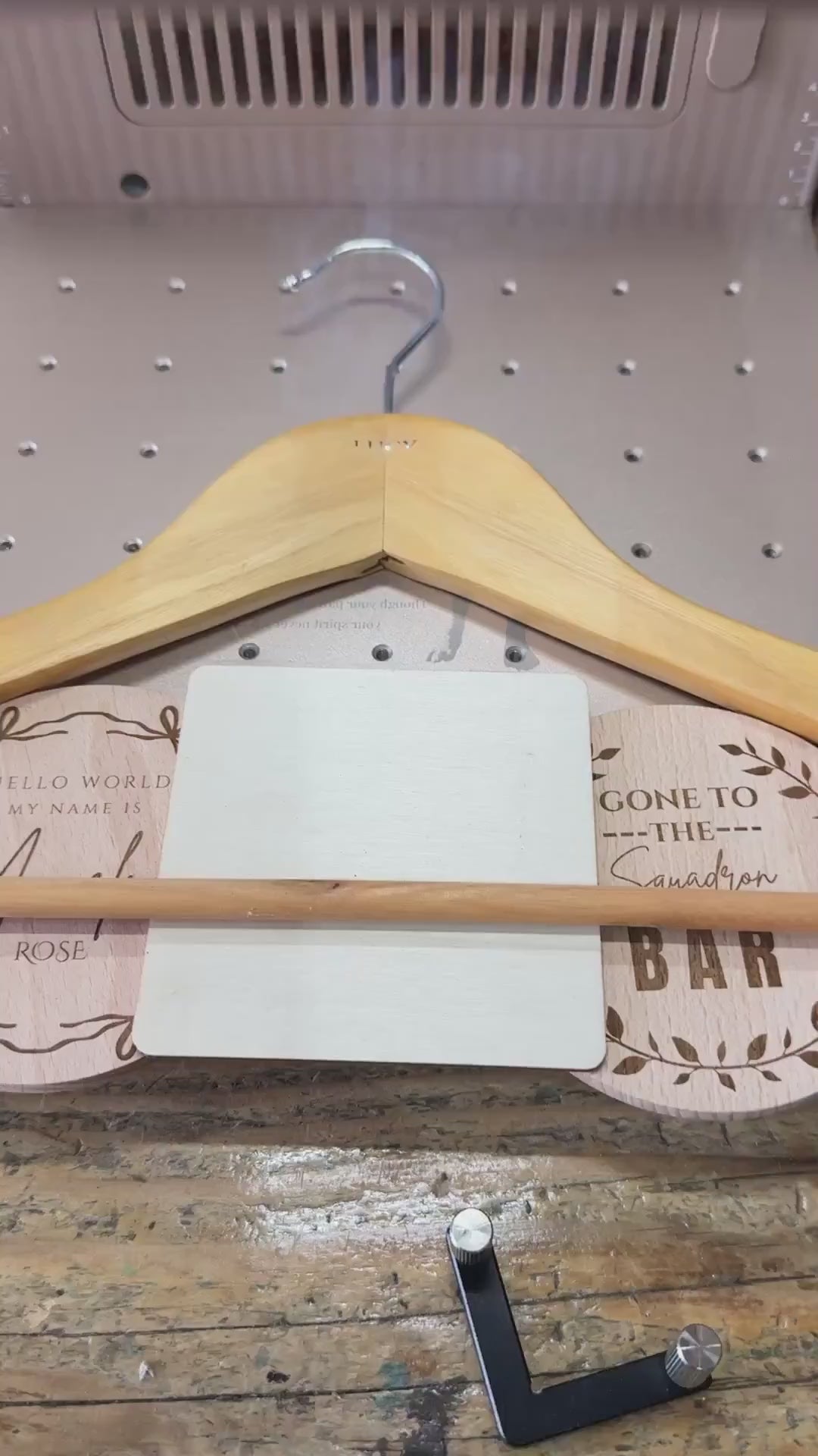 Personalised wooden wedding hanger being laser engraved