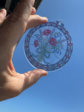 Wildflower bouquet stained glass effect acrylic suncatcher held up to the sky